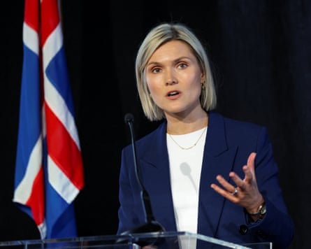 Kristrún Frostadóttir speaking at a lectern in front of Iceland's flag