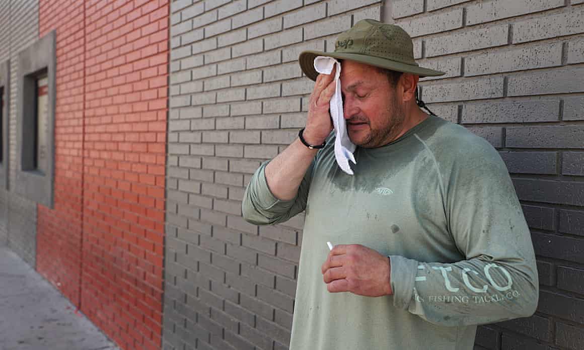 A man wipes his brow