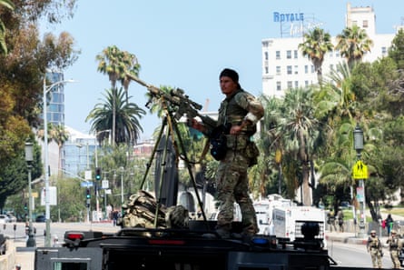 A man stands on an armoured vehicle at an IcerRaid at MacArthur Park, Los Angeles, US.