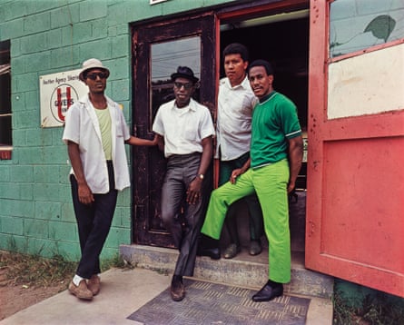 Four men standing in a doorway, looking at the camera