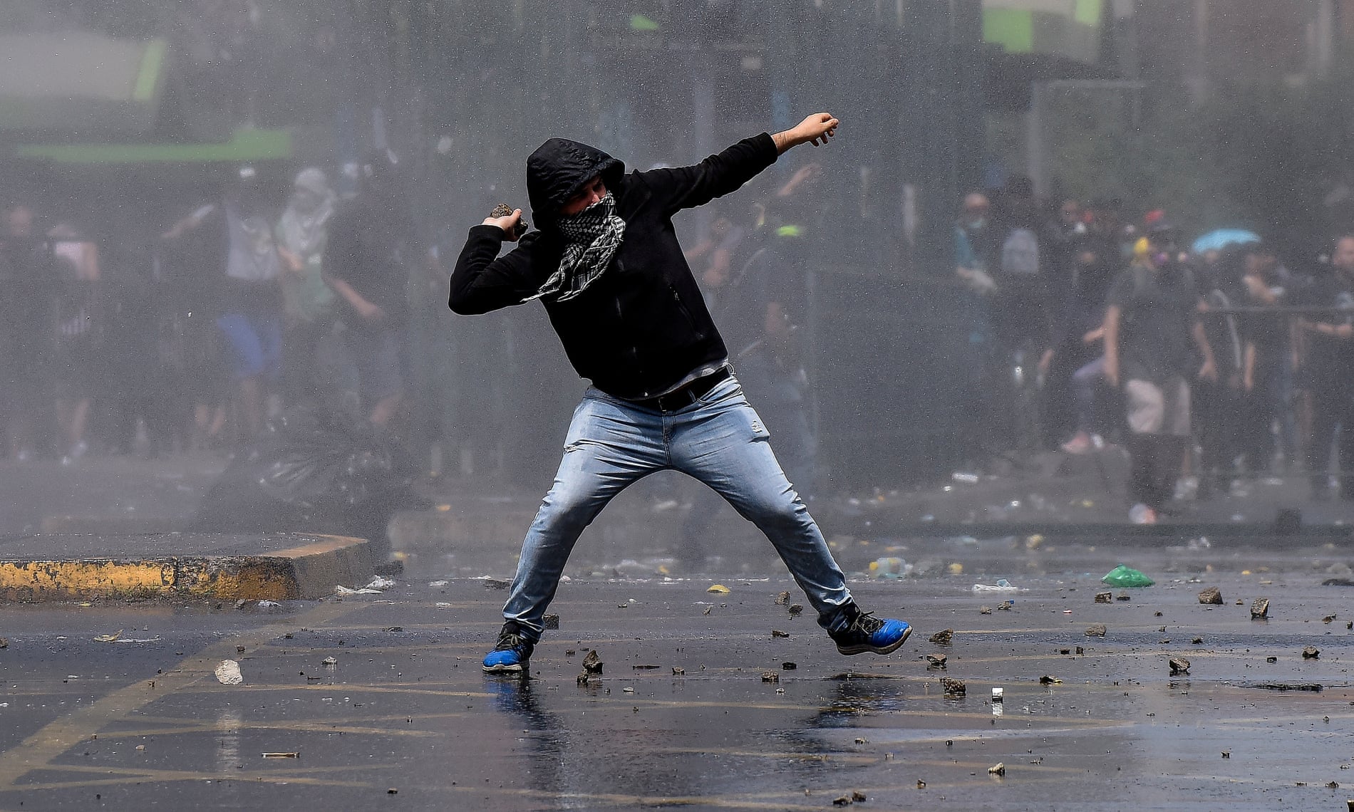 A demonstrator clashes with riot police during protests in Santiago, Chile