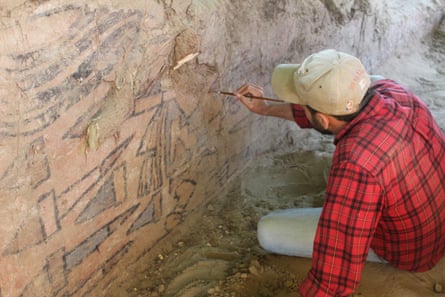 Sâm Ghavami uses a brush to reveal the mural.