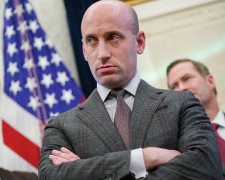 a bald man in a suit with arms folded