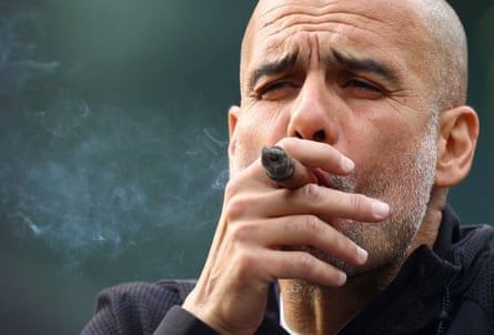 Pep Guardiola smokes a cigar as he celebrates winning the Premier League in 2022.