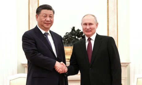 Vladimir Putin and Xi Jinping shaking hands.