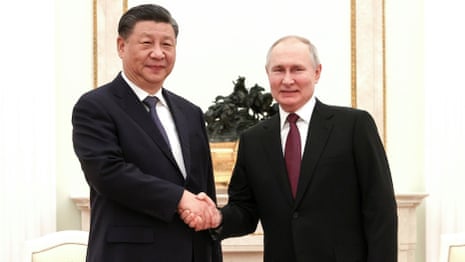 Vladimir Putin and Xi Jinping shaking hands.