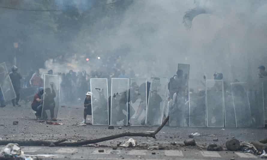 Colombia braces for further unrest after police react violently to mass protests 8 Demonstrators take cover behind makeshift shields in Cali, Colombia, on 30 April.