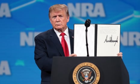 Trump shows the NRA crowd the signed document rejecting the UN arms trade treaty. Trump also told the crowd: ‘The level of corruption and dishonesty in the media is unbelievable.’