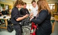 Secondary school vocational practical education Wales UK: A woman teacher teaching year 12 and 13 6th form teenage boys about a car engine in a mechanical engineering class lesson<br>ECTJF4 Secondary school vocational practical education Wales UK: A woman teacher teaching year 12 and 13 6th form teenage boys about a car engine in a mechanical engineering class lesson