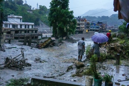 Flooding in the Bhotekoshi River where people look out at the damage