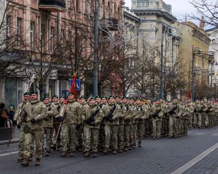 سربازان ملبس یونیفرم، برخی با اسلحه، بهصورت هماهنگ قدم میزنند