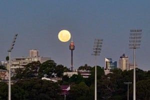 Sydney, Australia. The moon is seen above the city, with a stadium in the foreground