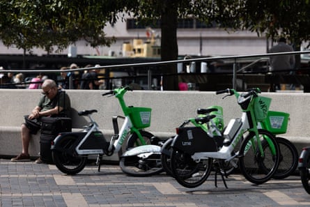 A man sits by Lime bikes at Circular Quay, Sydney