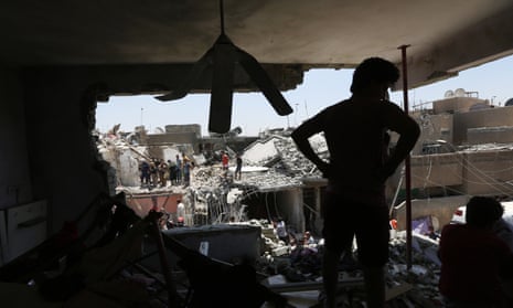 People stand in rubble after a bombing in the eastern neighborhood of New Baghdad on July 6, 2015. At least a dozen civilians were killed on when a Russian-made fighter jet accidentally dropped a bomb over a Baghdad neighborhood.