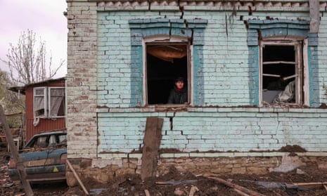 A local resident looks out from her partially destroyed house after missile strikes in the town of Kostyantynivka, Donetsk region.