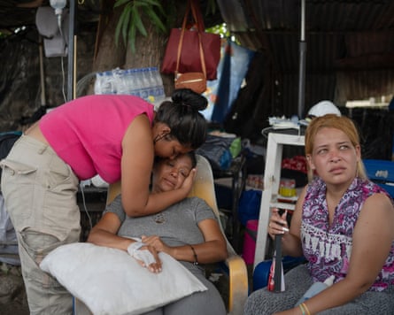 Carmen Guedez comforts her mother, Yaritza García, at their makeshift shelter on the ninth day after the double earthquake on 24 June 2026