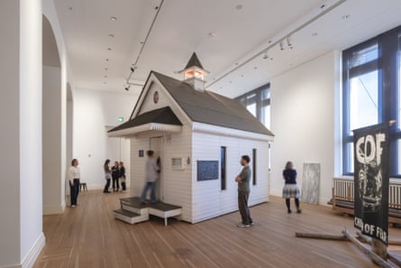 A small church is built inside a large gallery space