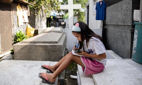 Lovely Joy de Castro, 11, takes part in at an online class in the Manila cemetery where her family lives. 