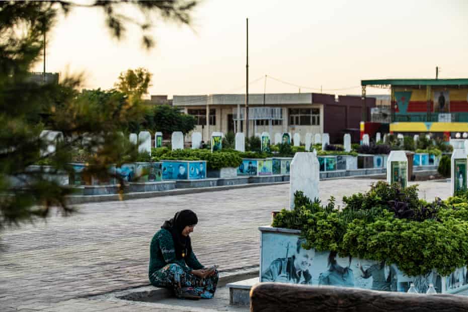 A Syrian woman reads the Qur’an near the grave of her daughter, a fighter in the Women’s Protection Forces, in the city of Qamishli