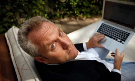 Andrew Breitbart looks up at the camera while holding a laptop