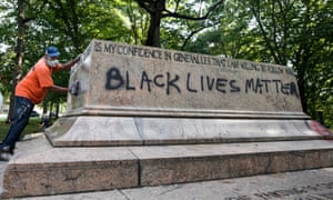 City workers remove graffiti from the base of what was once the Jackson-Lee Monument, a Confederate statue in Wyman Park, Baltimore.