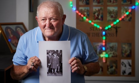 Michael Lachmann in his home holding a picture of himself when he first arrived in Australia straight off the boat