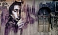 A mural in Kolkata of a pensive woman looking cautiously from behind a wall, painted in dark monotones.