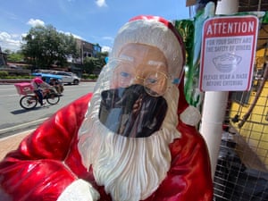 A Santa Claus figure with a face mask and a face shield is at a store in Manila in September.
