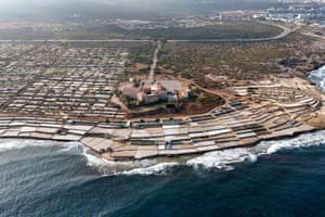 An aerial photograph of the sea lapping up against concrete-lined basins