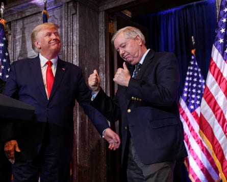 Donald Trump grins as Lindsey Graham give a thumbs up next to two US flags
