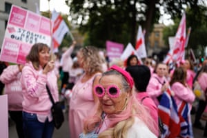 People in pink hoodies, dresses hold placards as well as union and St George’s flags