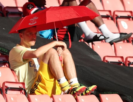 Mesut Ozil shelters from the sun under a Southampton umbrella.