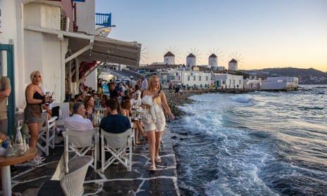A seafront restaurant at  Little Venice, Mykonos, with the island’s famous windmills in the background.