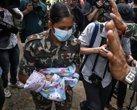 A soldier carries a rescued infant at Trishuli camp in Nepal