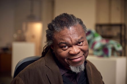 Yinka Shonibare smiling with art works in the background