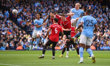 Erling Haaland heads the first of his three goals for Manchester City against United.