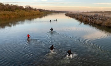 Overhead view of 7 people wading across the river