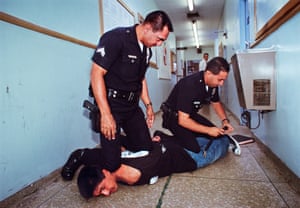 Rampart Division Officers detaining an arrested man.Officers at the Rampart Station restrain a man resisting arrest