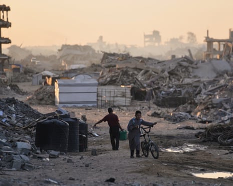 Palestinians walk trough the destruction caused by the Israeli air and ground offensive in Sheikh Radwan neighbourhood in Gaza City, Wednesday, 22 October 2025.