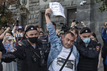 Police detain a supporter of Alexei Navalny in front of the federal security service building on Thursday.