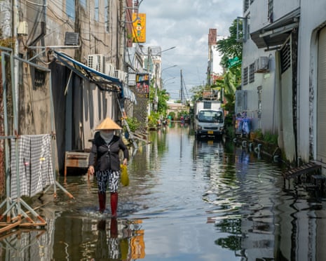 A person walking down a flooded street in Ca Mau, Vietnam, on November 12, 2025.