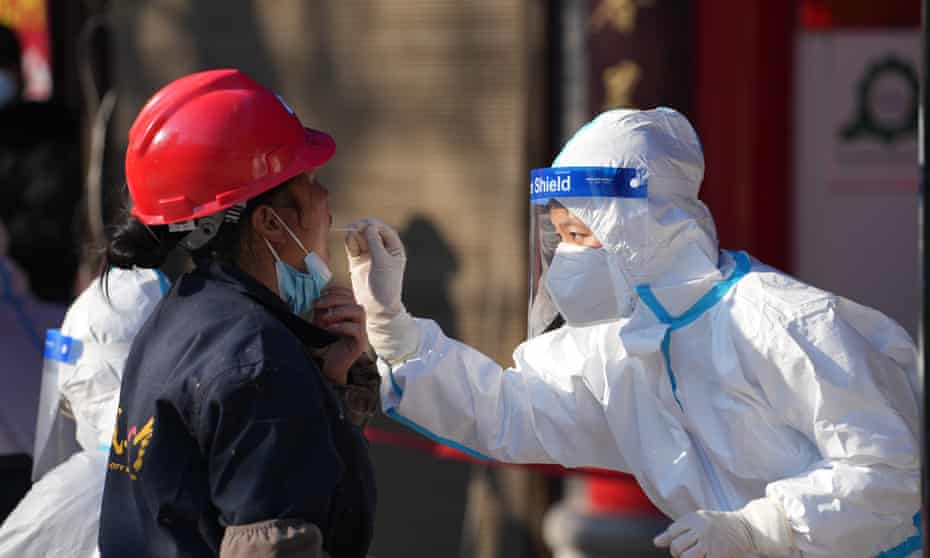 A health worker collects a swab sample at a Covid-19 testing site in Xi'an, which has been placed into a lockdown.