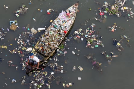 A resident using a wooden boat to clean plastic waste in the Citarum River in Batujajar, Bandung, West Java, Indonesia, earlier this year.