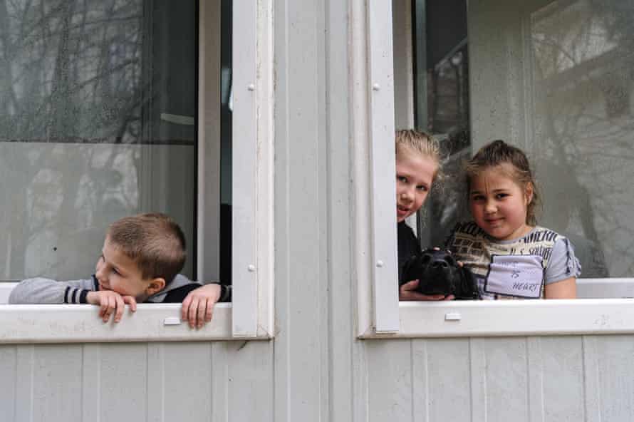 Ukrainian children seen looking outside of windows.