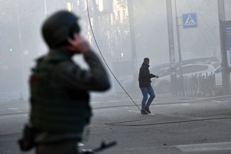A local resident runs away after a drone attack as security forces watch on.