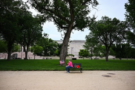 A woman listens from afar during the Unite for Veterans, Unite for America Rally at the National Mall on 6 June 2025 in Washington.