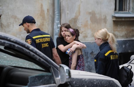 Locals react after an apartment block was damaged by a strike in Lviv.