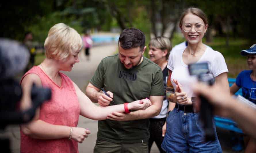 Volodymyr Zelenskiy signs on an arm of a supporter in Zaporizhzhia.