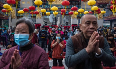 People wear masks as they pray at a temple in Hong Kong