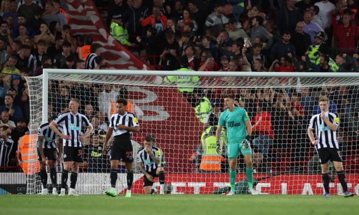 Newcastle United players and fans (left) look dejected after Liverpool’s second goal.